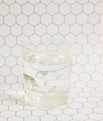 Glass of water on hexagon pattern background.
