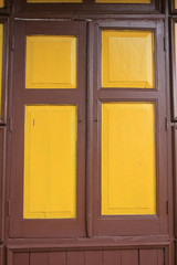 old wooden style windows with mustard yellow painted color