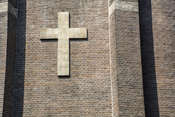 Brown big cross on the brick wall
