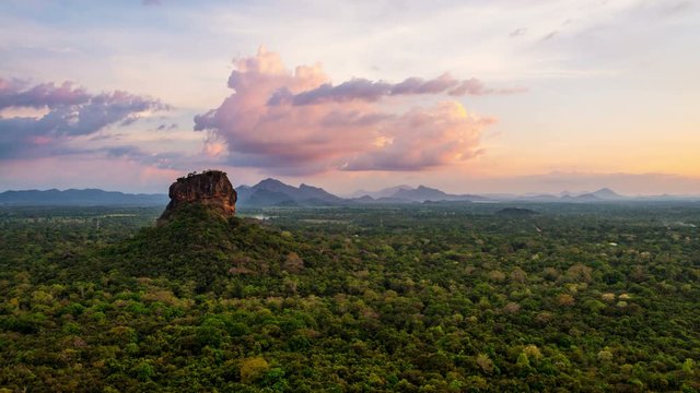 View of people going down the Lion Rock in Sigiriya, Sri Lanka. Aerial view of the tropical forest with mountains. Time-lapse of sunset sky