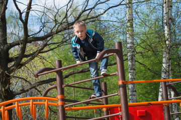 The boy climbed the ladder on the playground