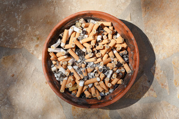 Big pile of put out cigarettes in an ashtray