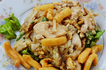 stir fried large noodle with chicken on dish