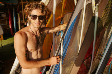 Professional young surfer getting surf board ready to catch waves
