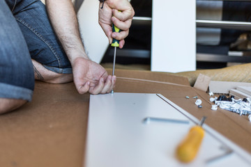 Unrecognizable person assemble furniture