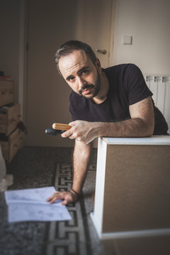 Bearded man with screwdriver looking at camera