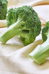Closeup of fresh broccoli on beige tablecloth. Copy space