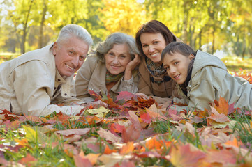 Happy family relaxing in autumn forest