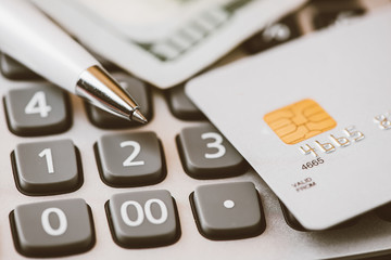 Credit card and ball pen on a calculator