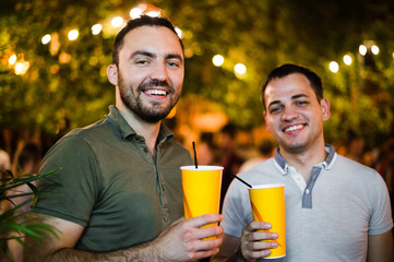 Alcoholics people drinking and having fun at outdoors cafe or park. Smiling couple alcohol friendship concept.