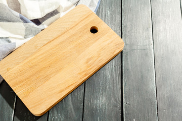 empty wooden board with tablecloth on dark desk