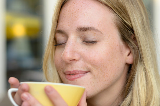 Happy young woman enjoying her morning coffee