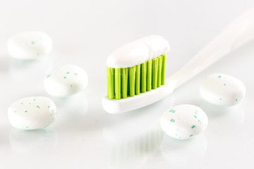 Fototapeta na wymiar sqweezed green toothbrush on white background with bubble gums