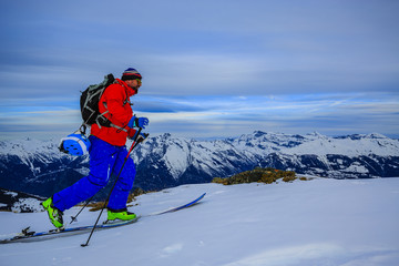 Ski touring in high mountains in fresh powder snow before sunris