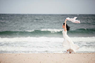 Fototapeta na wymiar Bride dances on the sand