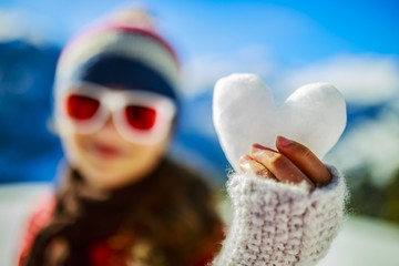 I love winter, smiling teenager holdin heart of snow.