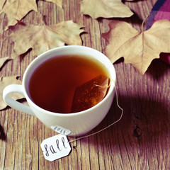 a cup with a tea bag with the word fall in its label