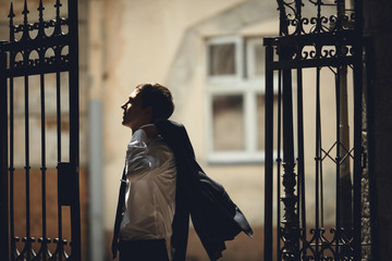 groom  posing for photographer at the high gates