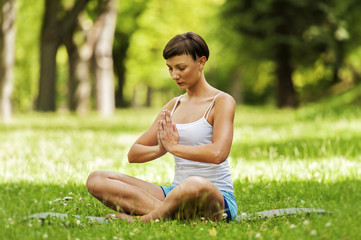 Naklejka na ściany i meble Zen yoga position woman on the grass.