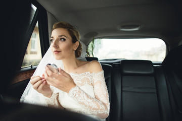 bride adjusts makeup in the car