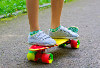 young boy learning to ride skateboard in the suburb street having fun.