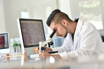 Student in biology using microscope in training class