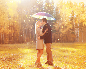 Happy romantic kissing couple in love with colorful umbrella tog