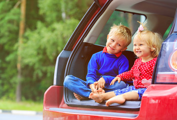 happy little boy and toddler girl travel by car