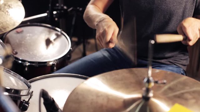 male musician playing drums and cymbals at concert