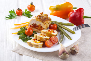 chicken rolls with tomato and paprika on white plate