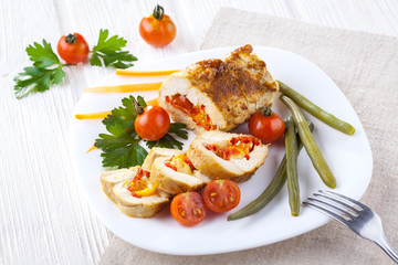 chicken rolls with tomato and paprika on white plate