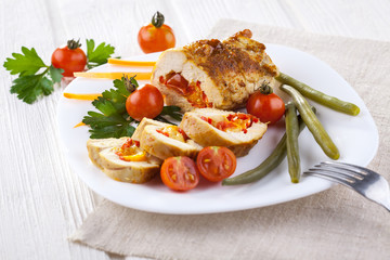 chicken rolls with tomato and paprika on white plate