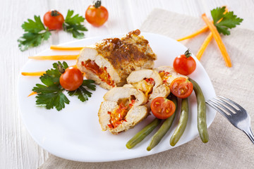 chicken rolls with tomato and paprika on white plate