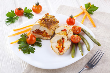 chicken rolls with tomato and paprika on white plate