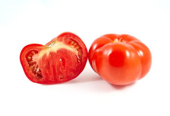 A tomato. Red tomato on a white background. Harvest vegetables. Autumn harvest. Red, juicy, ripe tomato.