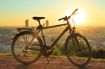 Urban sports bicyle and a warm sunrise over Lyon, France.