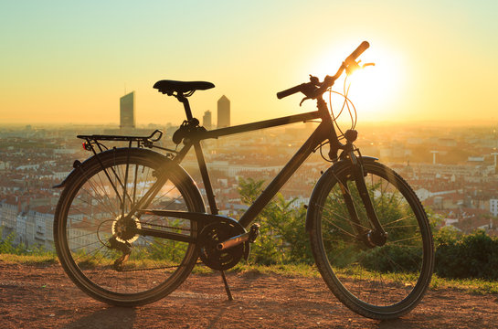Fototapeta Urban sports bicyle and a warm sunrise over Lyon, France.