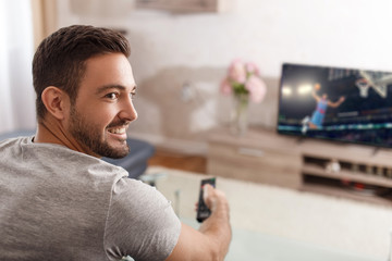 Excited man switch TV to basketball