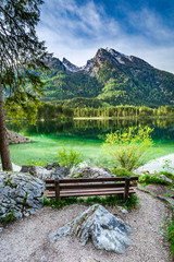 Naklejka premium Wooden bench at the Hitersee lake in the Alps, Germany