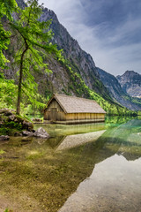 Fototapeta na wymiar Obersee lake at spring and small wooden cottage, Alps, Germany