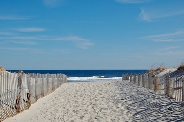 Sunny beach day, waves crashing and blue skies 