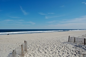 Sunny beach day, waves crashing and blue skies 