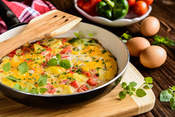 Traditional Frittata with potato, cheese, bell pepper and herbs