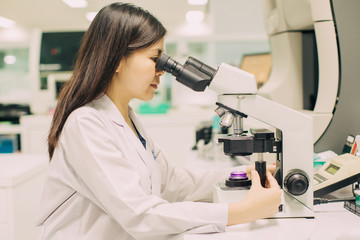 medical technologist is working in the laboratory. Using a microscope for detect the objects that...