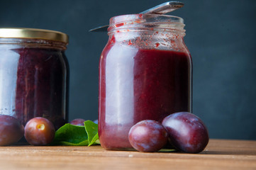 Fresh plum jam on a wooden background