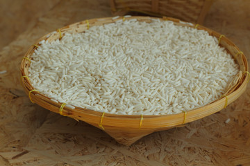 rice in weave basket on wood background
