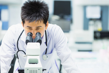 medical technologist is working in the laboratory. Using a microscope for detect the objects that...