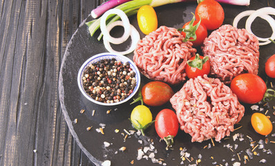 Fototapeta na wymiar raw minced meat, vegetables with salt and spices, selective focus