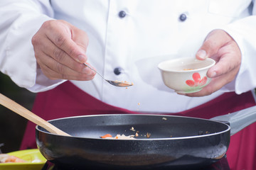 Chef putting crushed peanut to pan