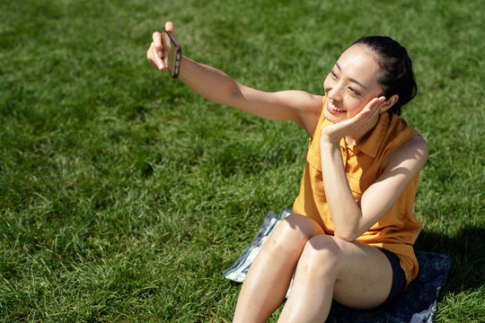 Asian woman in a city park talking selfie photo